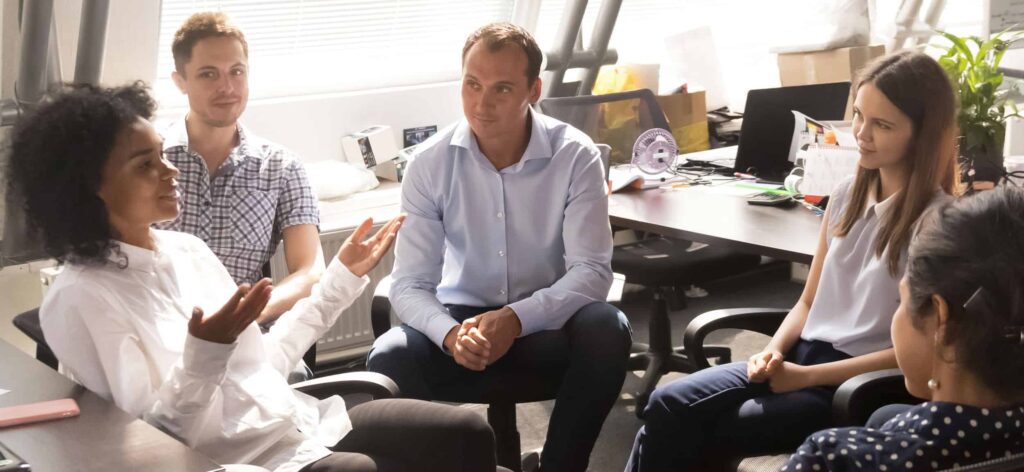 Teamcommunicatie tijdens overleg zonder laptops.